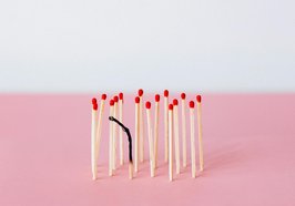 Mehrere neue Streichhölzer stehen auf einer rosafarbenen Fläche. Vorne mittig steht eines dazwischen, das abgebrannt ist. Foto: Nataliya Vaitkevich/pexels 