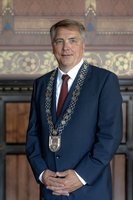 Oberbürgermeister Jürgen Krogmann steht im Ratssaal und hat die Amtskette um den Hals. Foto: Oberbürgermeister Jürgen Krogmann sitzt am Schreibtisch. Foto: Assanimoghaddam/Mittwollen