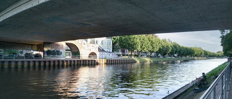 Blick unter einer Brücke hindurch auf den Oldenburger Hafen. Foto: Mittwollen und Gradetchliev