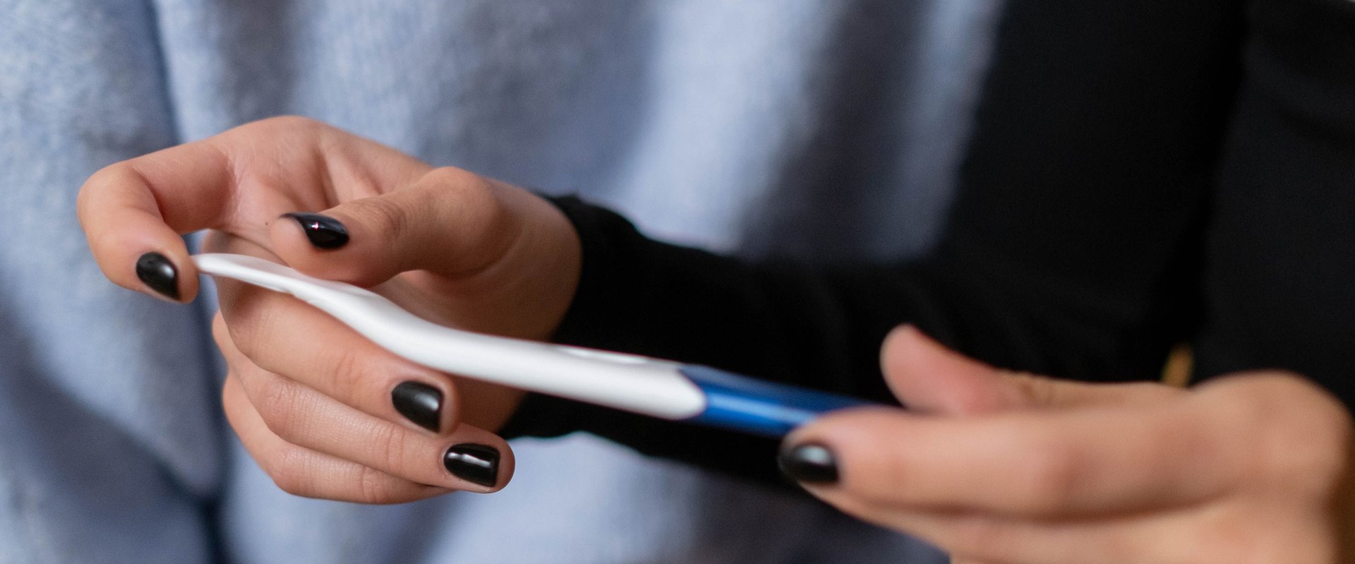 Frauenhände halten einen Schwangerschaftstest. Foto: Cottonbro/Pexels