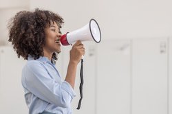 Frau mit Megaphon. Foto: David/ AdobeStock