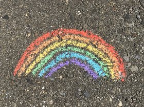 Mit Kreide auf den Asphalt gemalter Regenbogen. Foto: Alex Jackman/Unsplash
