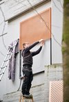 Montage eines Kunstwerks an der Wand. Foto: Foto- und Bilderwerk