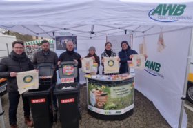 Mitarbeitende der Stadt Oldenburg stehen aufgereiht am Infostand zu nachhaltigem Konsum und halten nachhaltige Stofftaschen und Flyer in die Kamera. Foto: Sasche Stüber