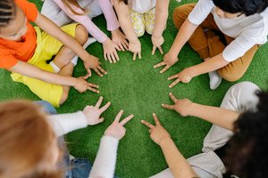 Junge Menschen halten ihre Hände in einen Kreis. Foto: Yankrukow/Pexels
