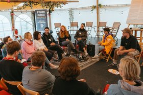 Menschen sitzen in einem Pavillon im Kreis. Foto: Florian Skupin 