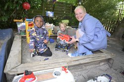 Tagesmutter Claudia Barkowsky mit zwei Kindern im Sandkasten. Foto: Sascha Stüber
