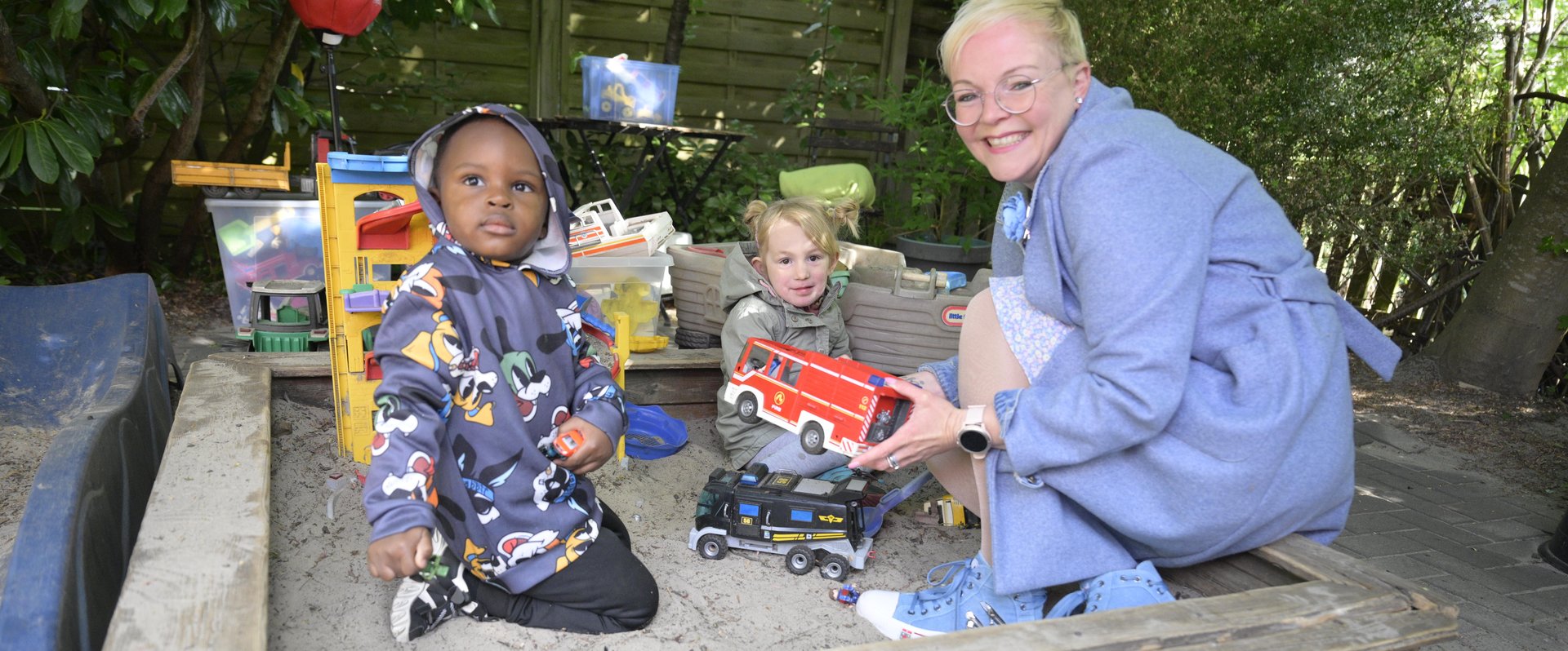 Tagesmutter Claudia Barkowsky mit zwei Kindern im Sandkasten. Foto: Sascha Stüber