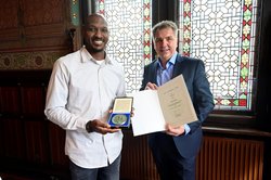 Oberbürgermeister Jürgen Krogmann (rechts) verlieh Rickey Paulding das Große Stadtsiegel. Foto: Sascha Stüber Oberbürgermeister Jürgen Krogmann (rechts) steht neben Rickey Paulding, der eine Schachtel mit dem Großen Stadtsiegel hält. Foto: Sascha Stüber