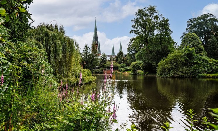 Teich im Schlossgarten mit der Lambertikirche im Hintergrund. Foto: Mittwollen und Gradetchliev