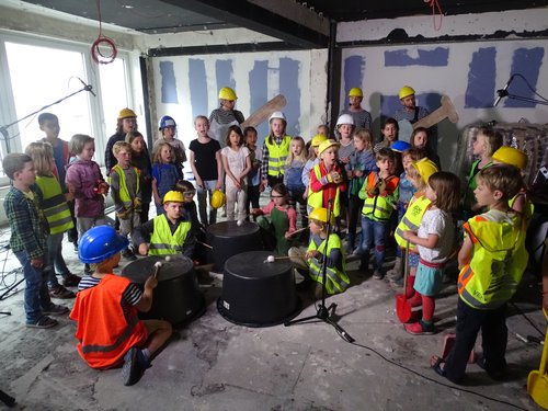 Die Blindfische mit den Kindern der Rappelkiste und dem Kinderchor beim Videodreh zum „Baustellensong“ auf der Baustelle der künftigen Musikschule. Foto: Stadt Oldenburg