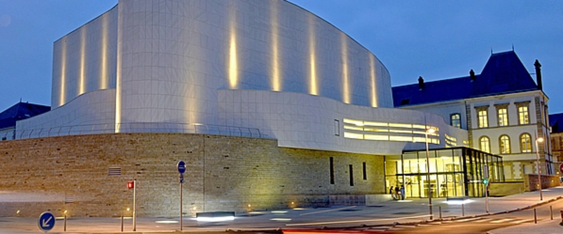 Théâtre Saint-Louis in Cholet bei Nacht, ein weißes, modernes Gebäude mit geschwungener Form. Foto: Mathilde Richard