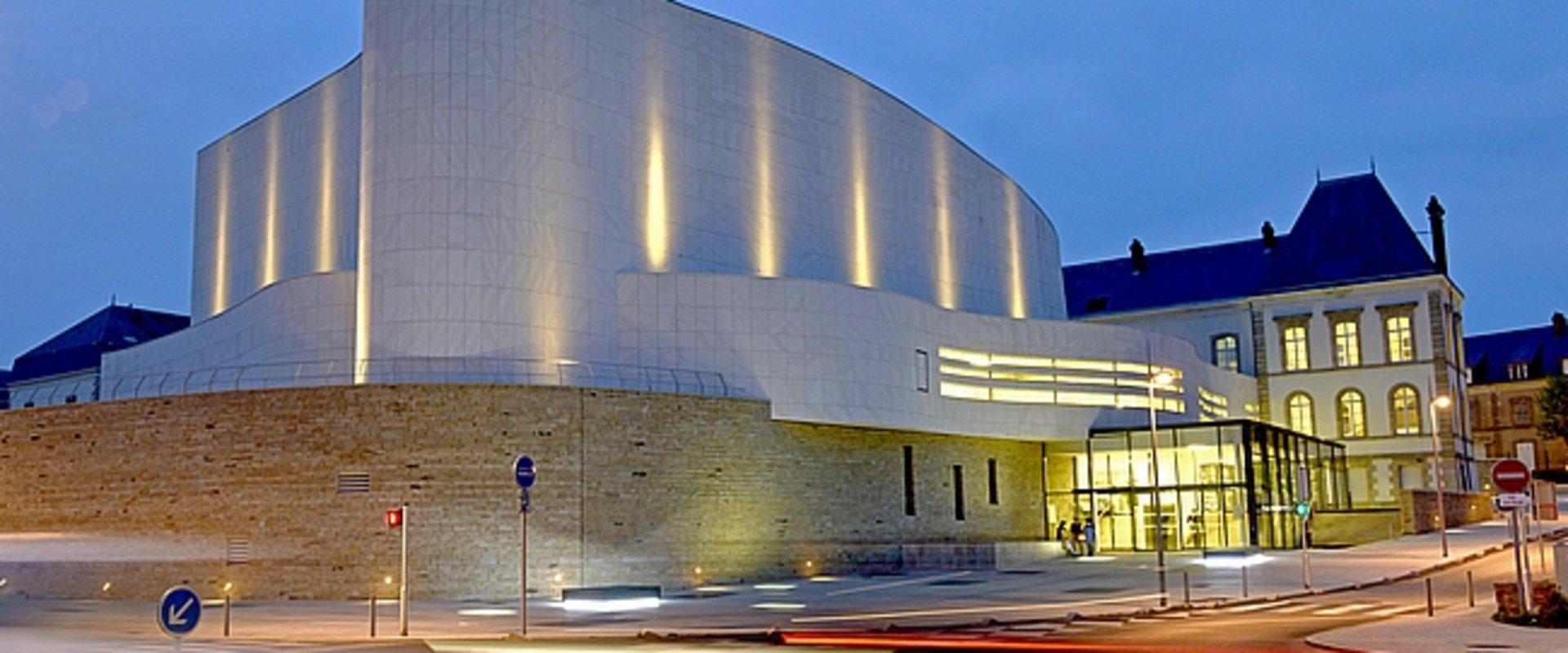 Théâtre Saint-Louis in Cholet bei Nacht, ein weißes, modernes Gebäude mit geschwungener Form. Foto: Mathilde Richard