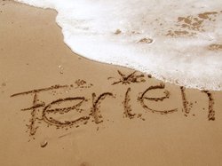 Schriftzug „Ferien“ im Sand. Foto: Rainer Sturm/Pixelio