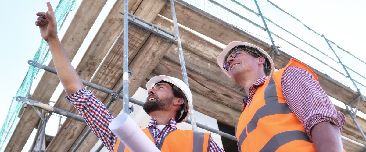 Zwei Männer mit Warnwesten auf einer Baustelle. Foto: industrieblick/Fotolia