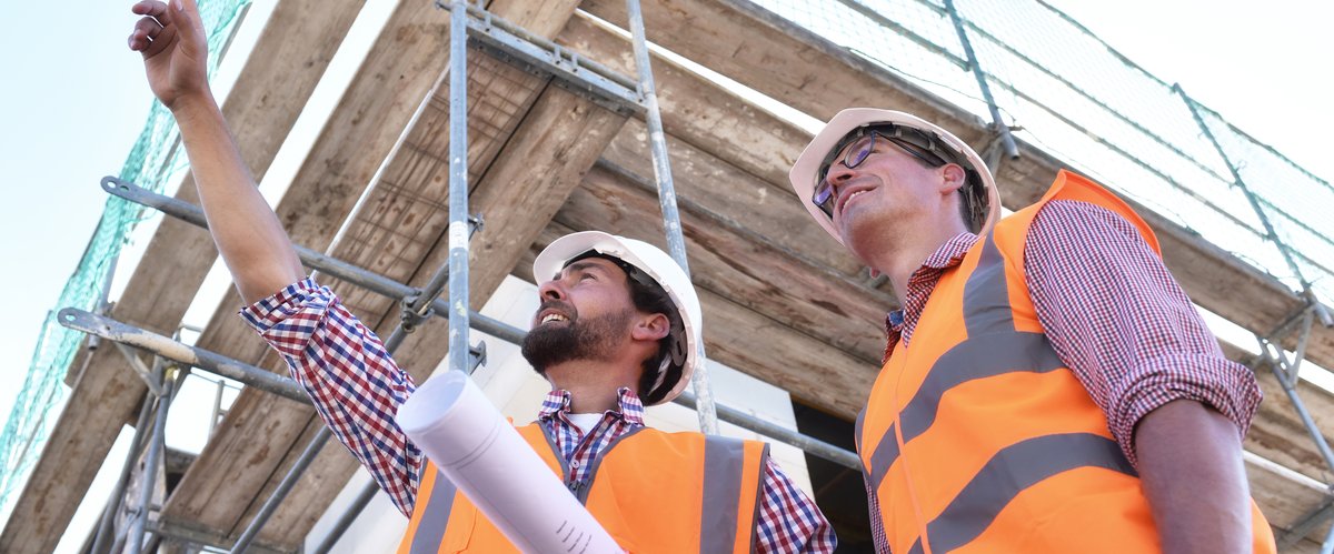 Zwei Männer mit Warnwesten auf einer Baustelle. Foto: industrieblick/Fotolia