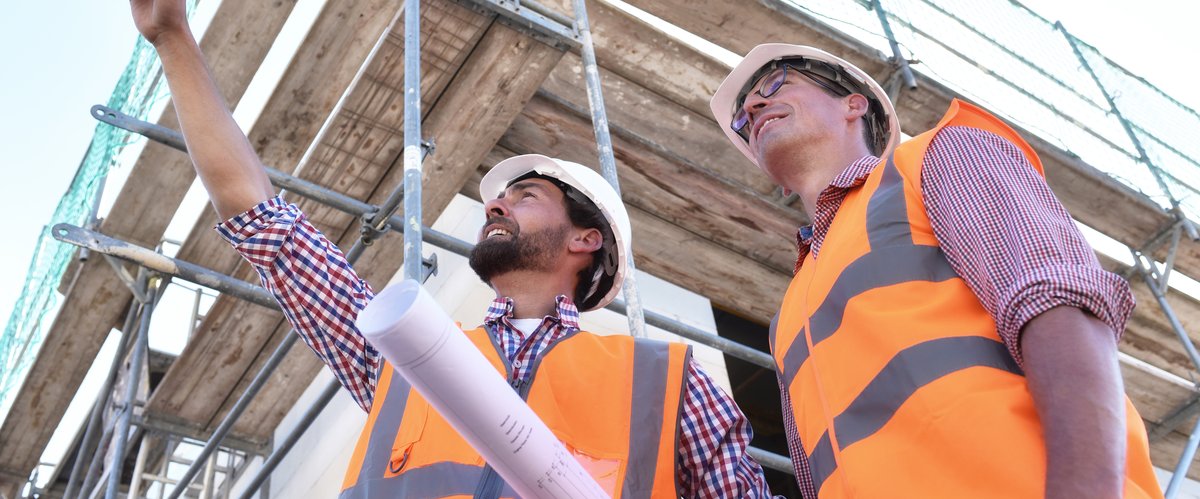 Zwei Männer mit Warnwesten auf einer Baustelle. Foto: industrieblick/Fotolia