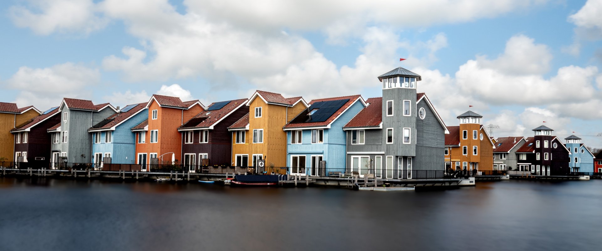  Bunte Häuser, Am Wasser, Blauer Himmel. Foto: Jolanda66/Pixabay