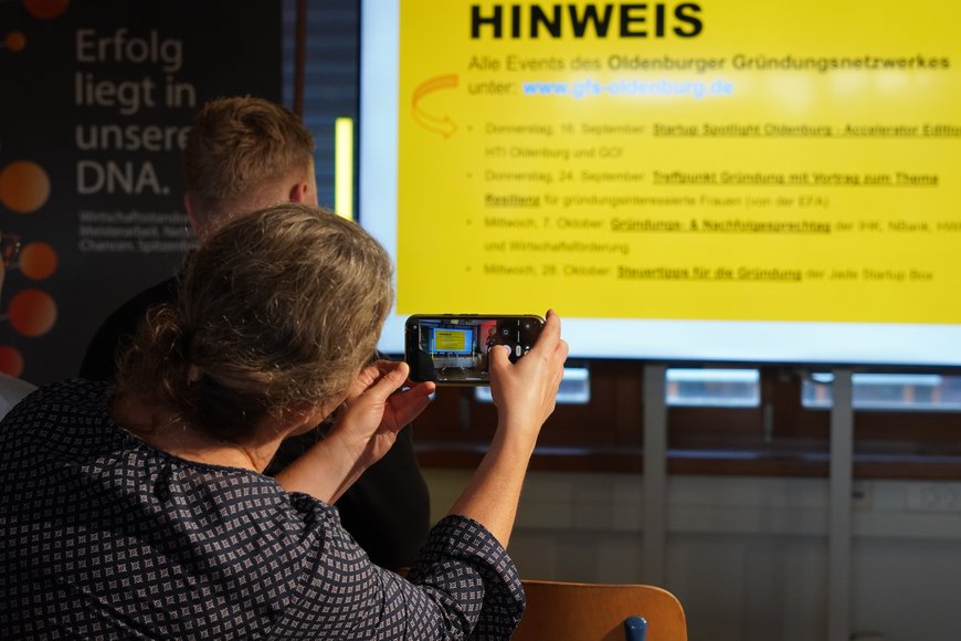 Teilnehmende fotografieren sich wertvolle Veranstaltungshinweise für ihre Gründung ab. Foto: TGO/GO!