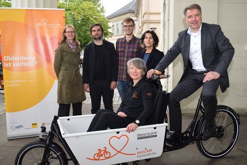 Oberbürgermeister Jürgen Krogmann (rechts) und STADTRADELN-Organisatorin Kerstin Goroncy (vorne) übergaben das Lastenrad an (hinten, von links) Claudia Bird, Ernst Schäfer und Maximilian Götz vom Verein „Rädchen für alle(s)“ sowie an Dr. Ursula Warnke vom Landesmuseum Natur und Mensch. Foto: Stadt Oldenburg.