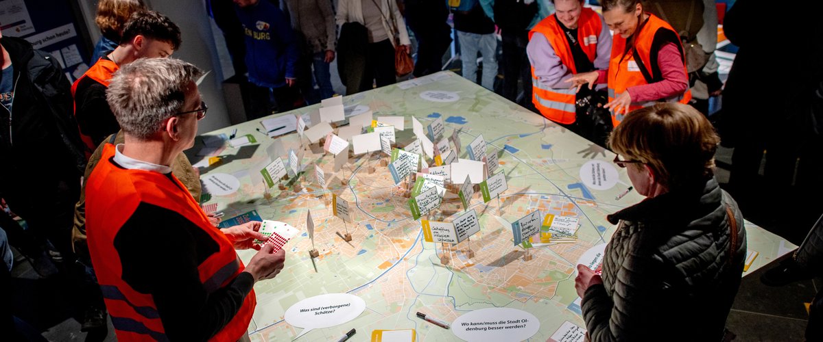 Viele Personen betrachten die Karte der Stadt Oldenburg mit den bereits lokalisierten Anmerkungen. Foto: Hauke-Christian Dittrich