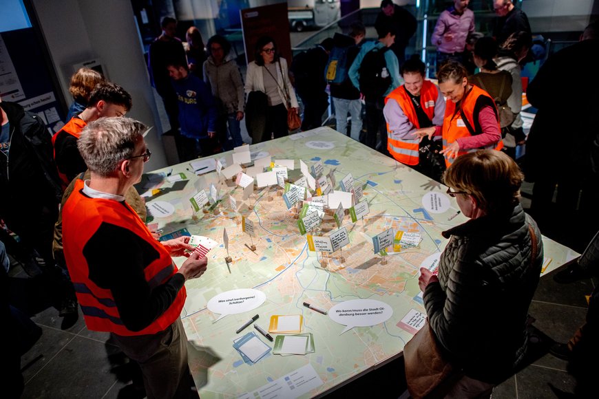 Viele Personen betrachten die Karte der Stadt Oldenburg mit den bereits lokalisierten Anmerkungen. Foto: Hauke-Christian Dittrich