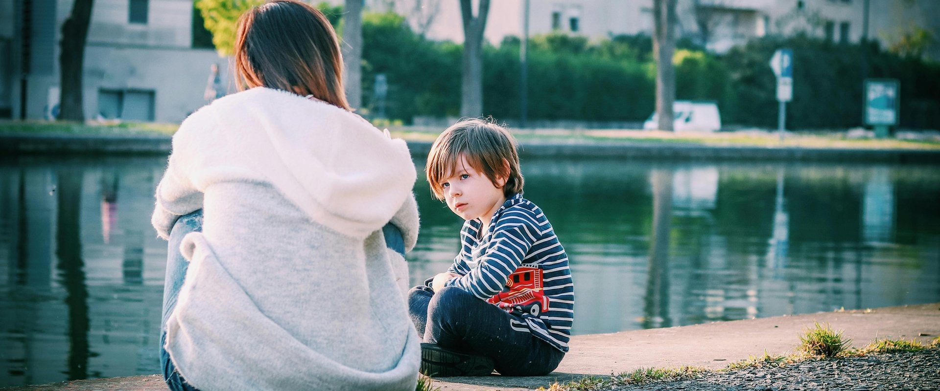 Mutter sitzt mit ihrem Sohn am Wasser. Foto: Rosivan Morais/Pexels