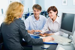 Mann und Frau im Gespräch mit einer Frau in einem Büro. Foto: pressmaster/Fotolia