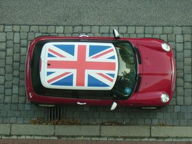 Blick von oben auf einen roten Minicooper mit Union Jack auf dem Dach. Foto: Jan von Broeckel/Pixelio.de