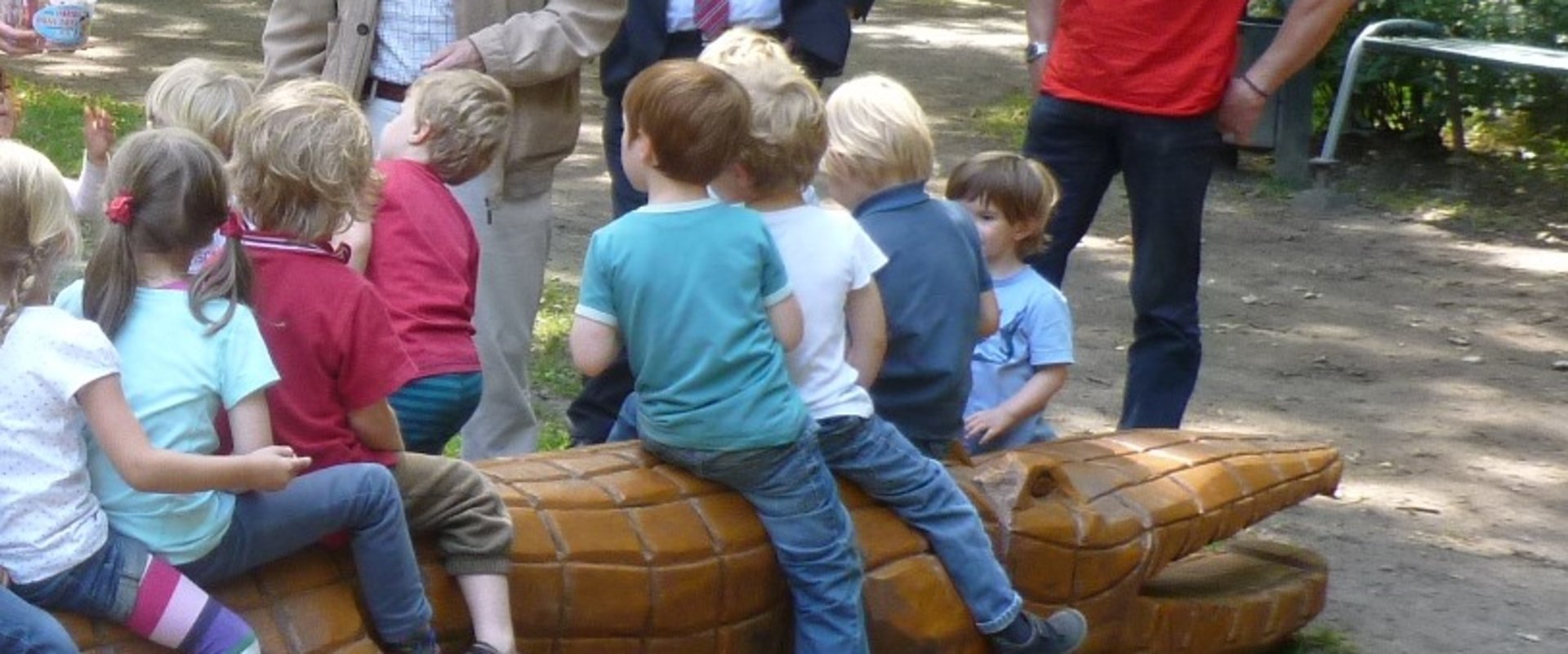 Spielende Kinder auf Holzkrokodil. Foto: Stadt Oldenburg