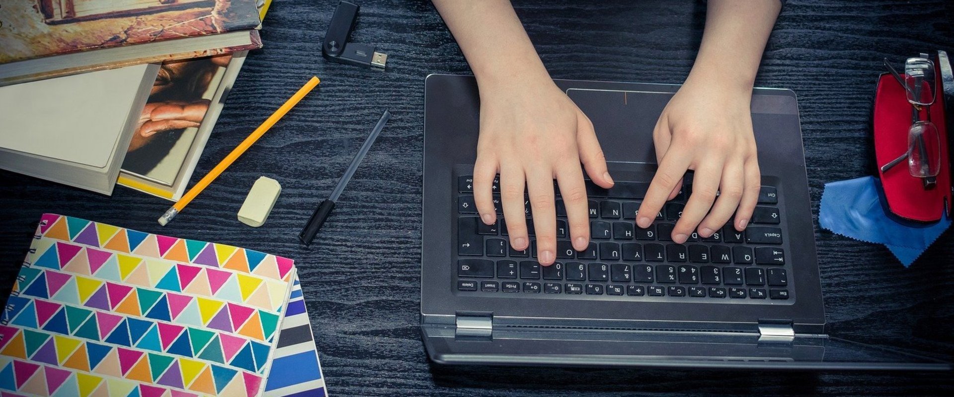 Hände, Notebook und Schreibunterlagen. Foto: khamkhor/Pixabay