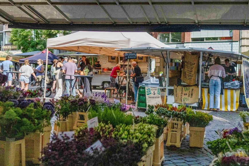 Blumen und Pflanzen mit Kaffeestand im Hintergrund auf dem Wochenmarkt auf dem Rathausmarkt. Foto: Sascha Stüber
