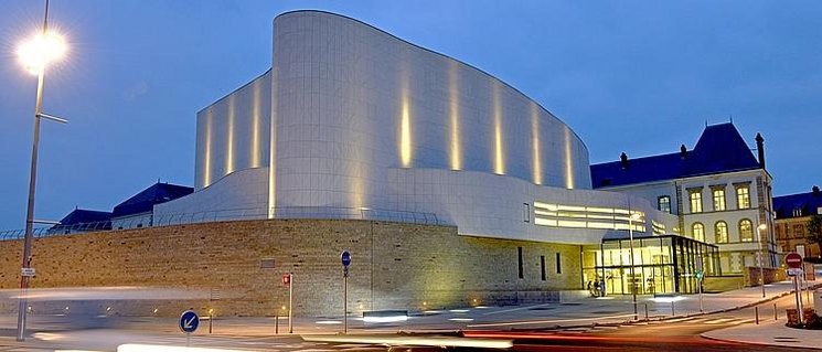 Théâtre Saint-Louis in Cholet bei Nacht, ein weißes, modernes Gebäude mit geschwungener Form. Foto: Mathilde Richard