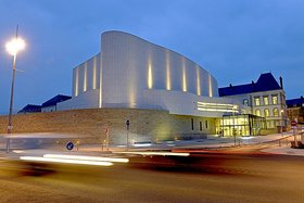 Théâtre Saint-Louis in Cholet bei Nacht, ein weißes, modernes Gebäude mit geschwungener Form. Foto: Mathilde Richard