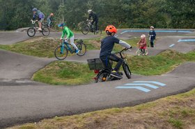 Kinder und Jugendliche mit Rädern und Roller auf dem Pumptrack. Foto: Sascha Stüber