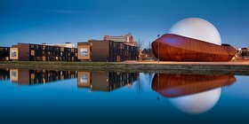 Eine moderne Gebäudereihe spiegelt sich in einem stillen Gewässer. Foto: Marketing Groningen