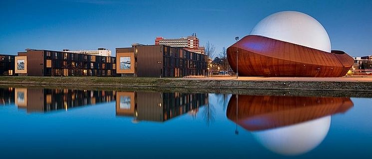 Eine moderne Gebäudereihe spiegelt sich in einem stillen Gewässer. Foto: Marketing Groningen