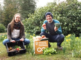 Zwei Personen mit einer Kiste mit frischem Obst und Gemüse und einem Pappwürfel mit der Aufschrift „Verantwortungsvolle Konsum- und Produktionsmuster“. Foto: Stadt Oldenburg