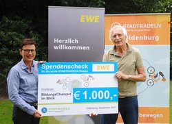 Marion Rövekamp, Vorständin EWE AG, übergibt den Scheck für das Erreichen des achten Etappenziels an Hansjürgen Otto, Vorsitzender BildungsChancen im Blick. Foto: Stadt Oldenburg Marion Rövekamp, Vorständin EWE AG, übergibt den Scheck für das Erreichen des achten Etappenziels an Hansjürgen Otto, Vorsitzender BildungsChancen im Blick. Foto: Stadt Oldenburg