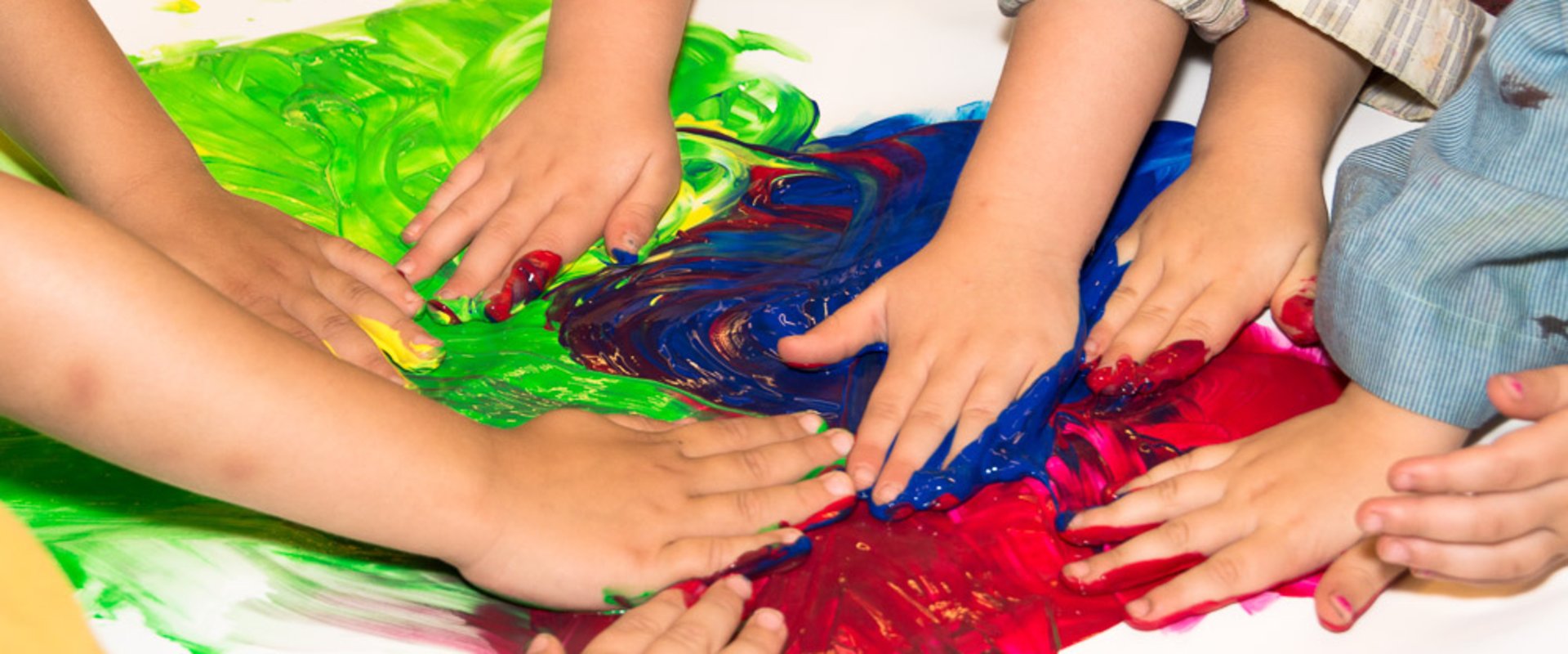 Kinderhände verschmieren bunte Farben. Foto: Stadt Oldenburg