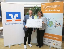 Christian Görres, Marktbereichsleiter Oldenburg der Oldenburger Volksbank eG, überreicht den Scheck für das Erreichen des sechsten Etappenziels an Angela Paradies, Vereinsvorsitzende Lichtblick e.V. Foto: Stadt Oldenburg