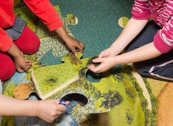 Kinderhände an einem großen Puzzle. Foto: Stadt Oldenburg