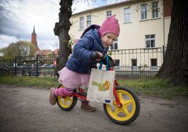 Mädchen mit Lesestart-Tasche auf Laufrad. Foto: Gordon Welters/Stiftung Lesen/Lesestart