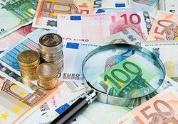 Geldscheine mit einer Lupe. Foto: alexandro900/Fotolia