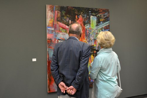 Besucher betrachten ein Gemälde von Michael Ramsauer. Besucher betrachten ein Gemälde von Michael Ramsauer.