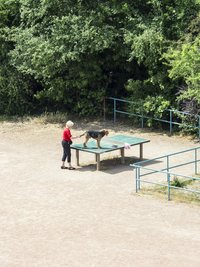 Eine ältere Frau mit einem Hund, der auf einer Tischtennisplatte steht. Foto: Hayahisa Tomiyasu Eine ältere Frau mit einem Hund, der auf einer Tischtennisplatte steht. Foto: Hayahisa Tomiyasu