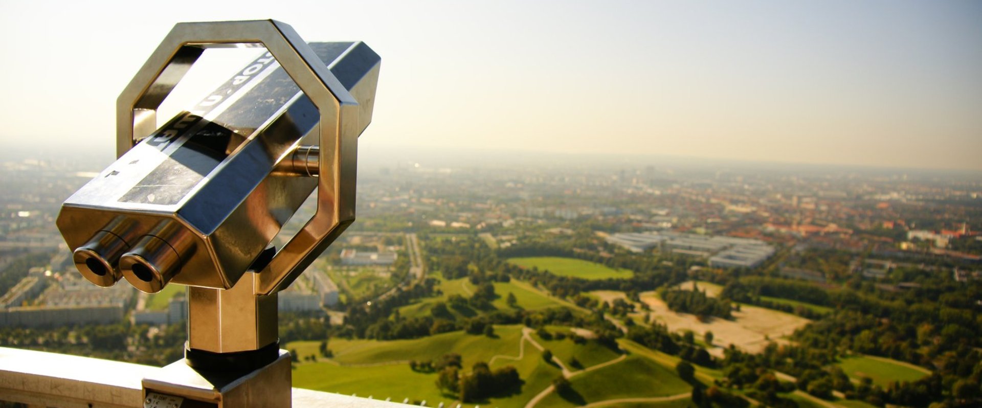 Es ist ein Fernrohr zu sehen, das auf eine grüne und besiedelte Landschaft gerichtet ist. Foto: Viktor Juncker/Pexels
