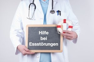 Arzt mit einer Tafel zu Hilfe bei Essstörungen und einem Rettungsring. Foto: HNFOTO/Adobe Stock Arzt mit einer Tafel zu Hilfe bei Essstörungen und einem Rettungsring. Foto: HNFOTO/Adobe Stock