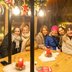 Vorschau: Eine Besuchergruppe in der Gondel bei der Feuerzangenbowle „Home Sweet Elf“ auf dem Lamberti-Markt 2025. Foto: Sascha Stüber