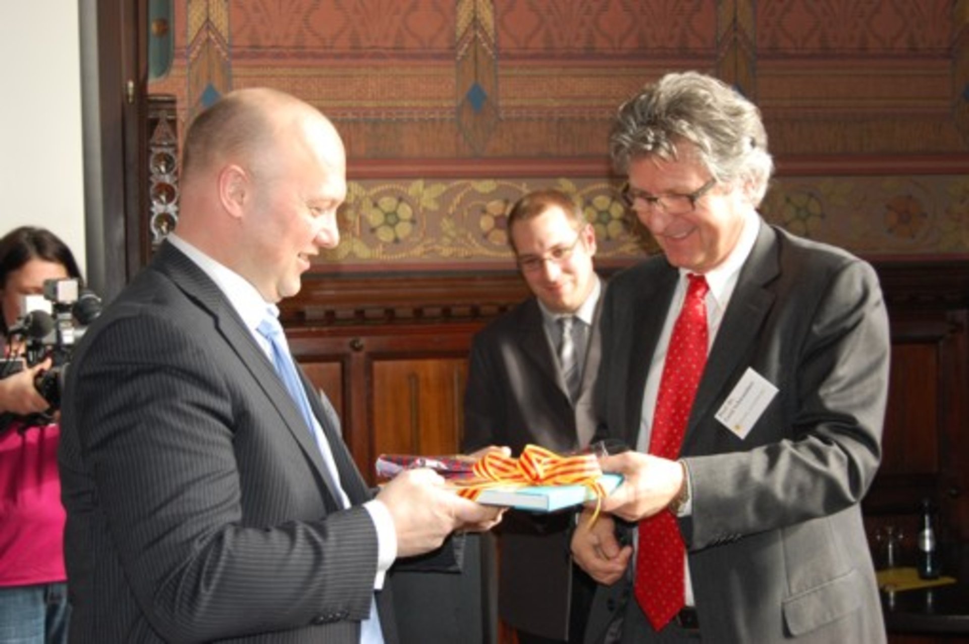 Oberbürgermeister Gerd Schwandner und Ton Schroor tauschen Geschenke aus. Foto: Stadt Oldenburg